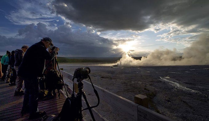 YS-Night-Skies-photographers_CarlyEverett_680 Photo workshop participants shoot the dramatic skies developing over a geyser in Yellowstone. Photo by Carly Everett