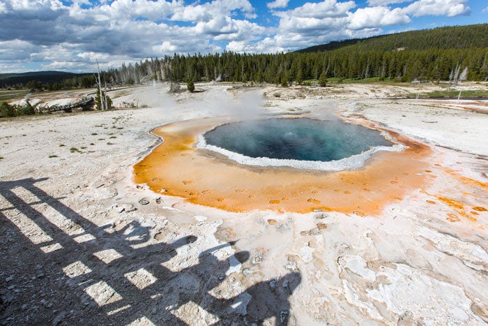 YS-CrestedPool-UpperGeyserBasin_NPSNealHerbertPD_700 Shadows of visitors at Crested Pool in Yellowstone's Upper Geyser Basin
