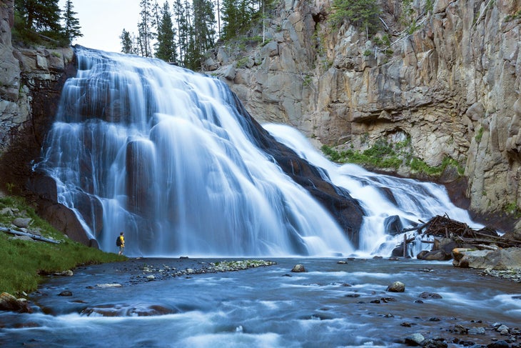 YS-Gibbon-falls-person_Ordelheide_1000 Man standing next to Gibbon Falls. Photo by Grant Ordelheide