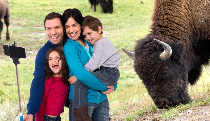 Family taking selfie next to bison