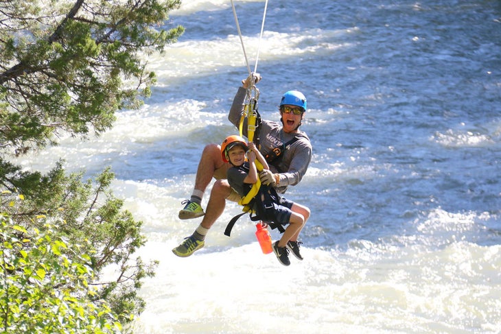 Tandem ziplining over the Gallatin River with expert guide at Montana Whitewater Big Sky location.